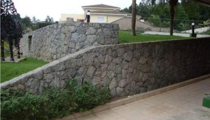 5.Muro de arrimo com pedra bruta para segurar o talude do terreno da  residência até a rua, sendo muro com certo…