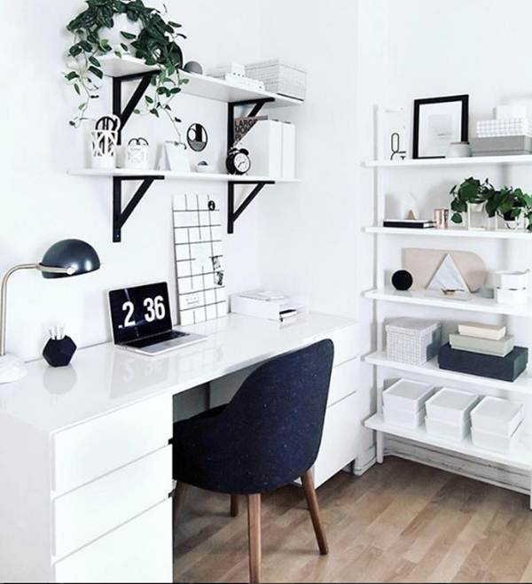Predominância do branco no escritório, contrastado com móveis e itens de decoração pretos.