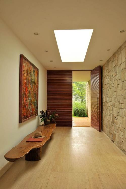 Porta de madeira que ocupa todo o vão da entrada, perfeita para casas com maior espaço.